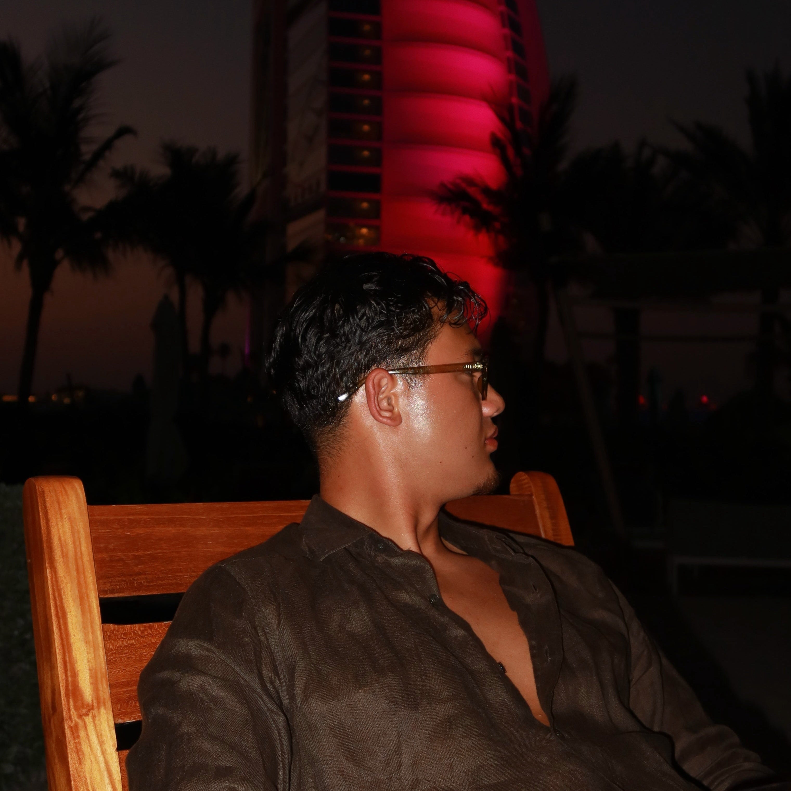 Man wearing luxvizio Amsterdam sunglasses in a luxury tropical sunset setting – modern minimalist eyewear brand inspired by European street style and designed for bold, stylish individuals.

