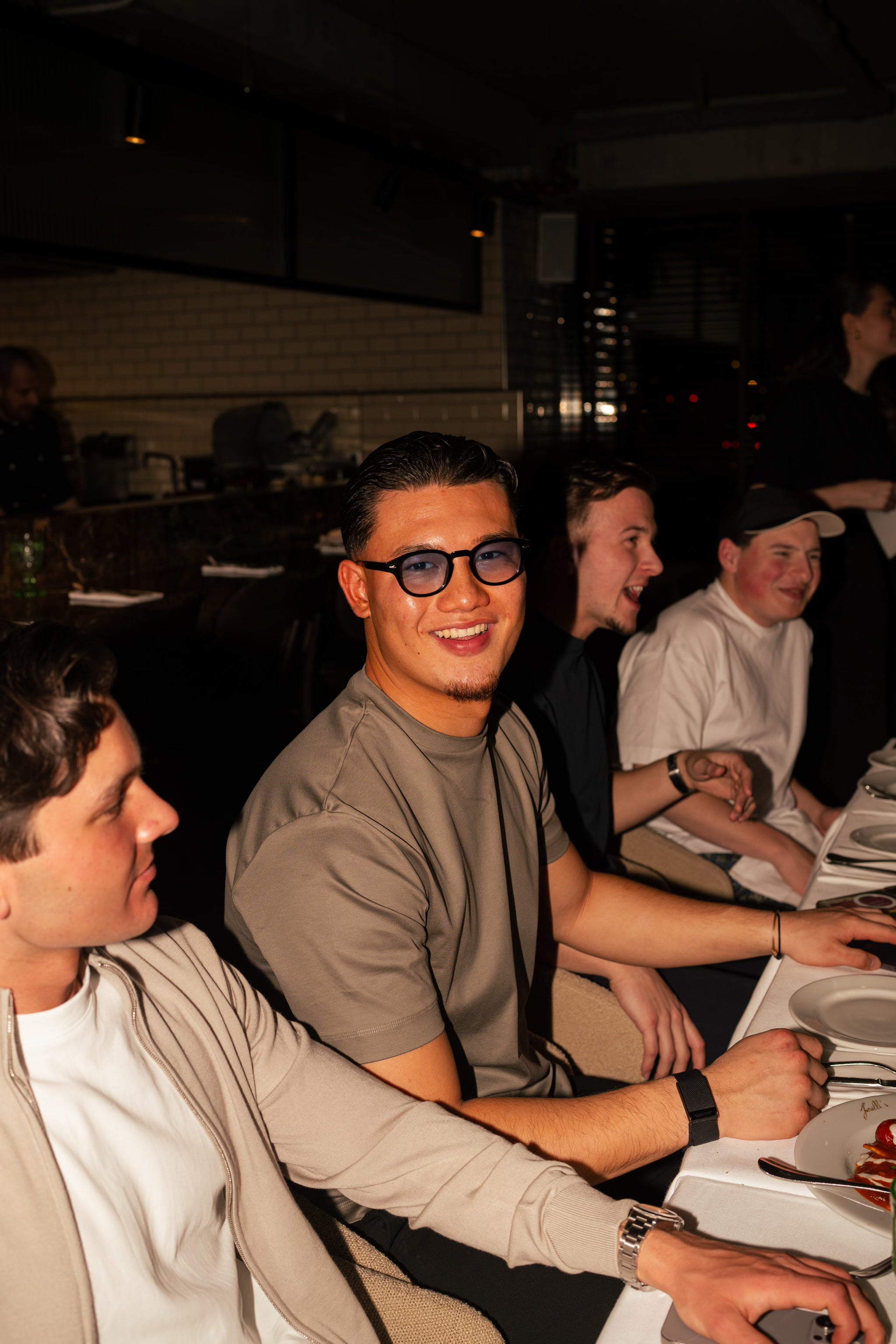 Stylish man wearing blue-lens luxvizio Amsterdam sunglasses during a vibrant night out at Ferrili's in Amsterdam – bold urban eyewear for confident individuals who embrace nightlife, fashion, and modern European luxury.