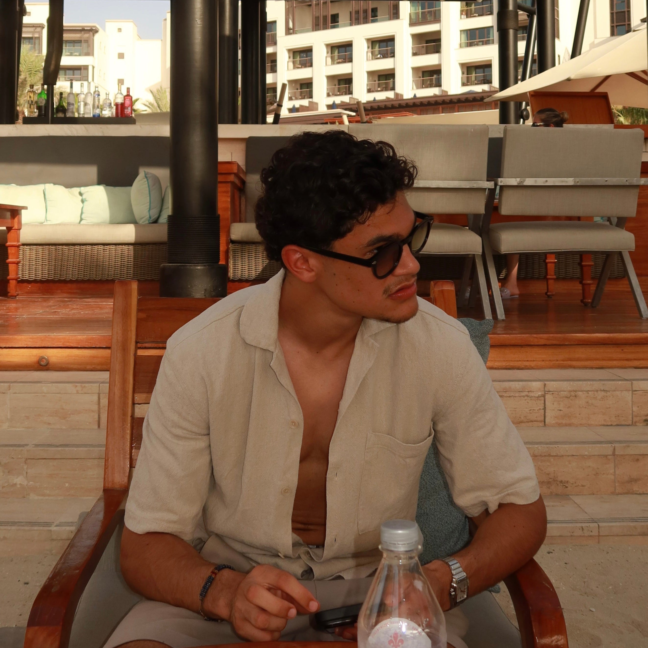 Confident man wearing luxvizio Amsterdam sunglasses at a luxury beachside resort – timeless men’s summer fashion meets modern minimalist eyewear, designed in Amsterdam for bold, fashion-forward lifestyles.